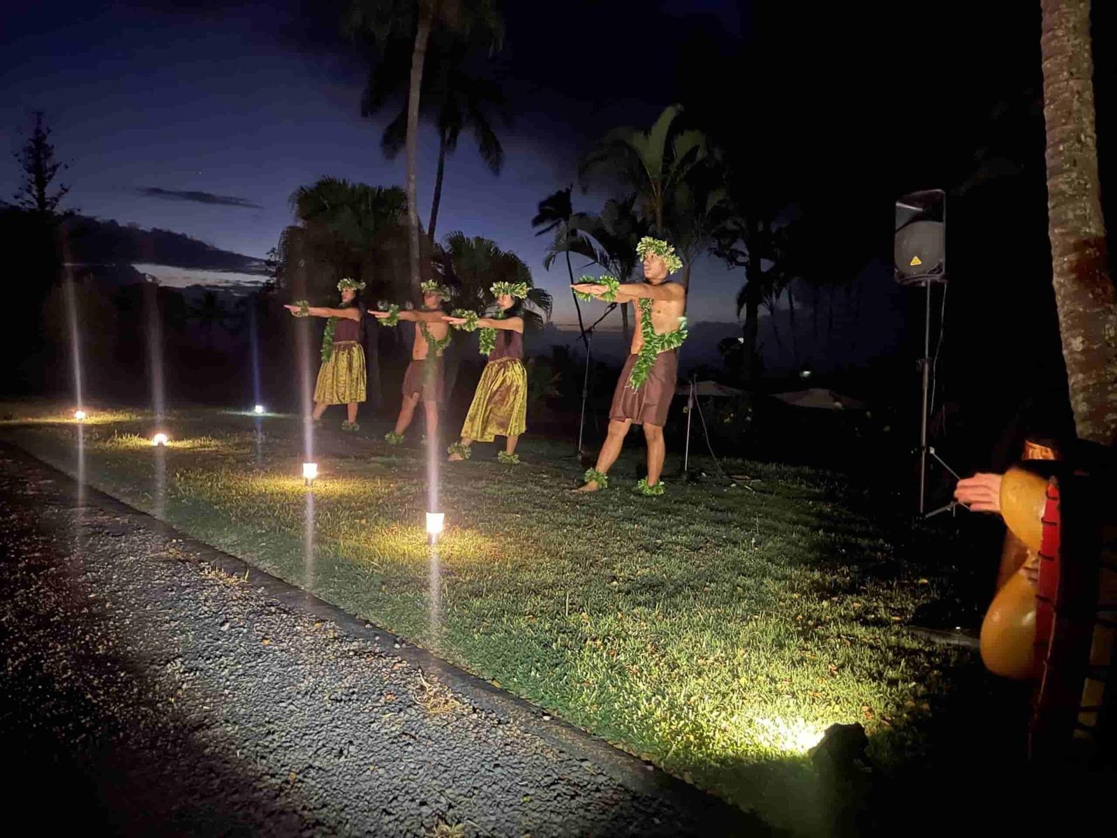Hula dancers performing on a lawn at dusk at a private Maui luau